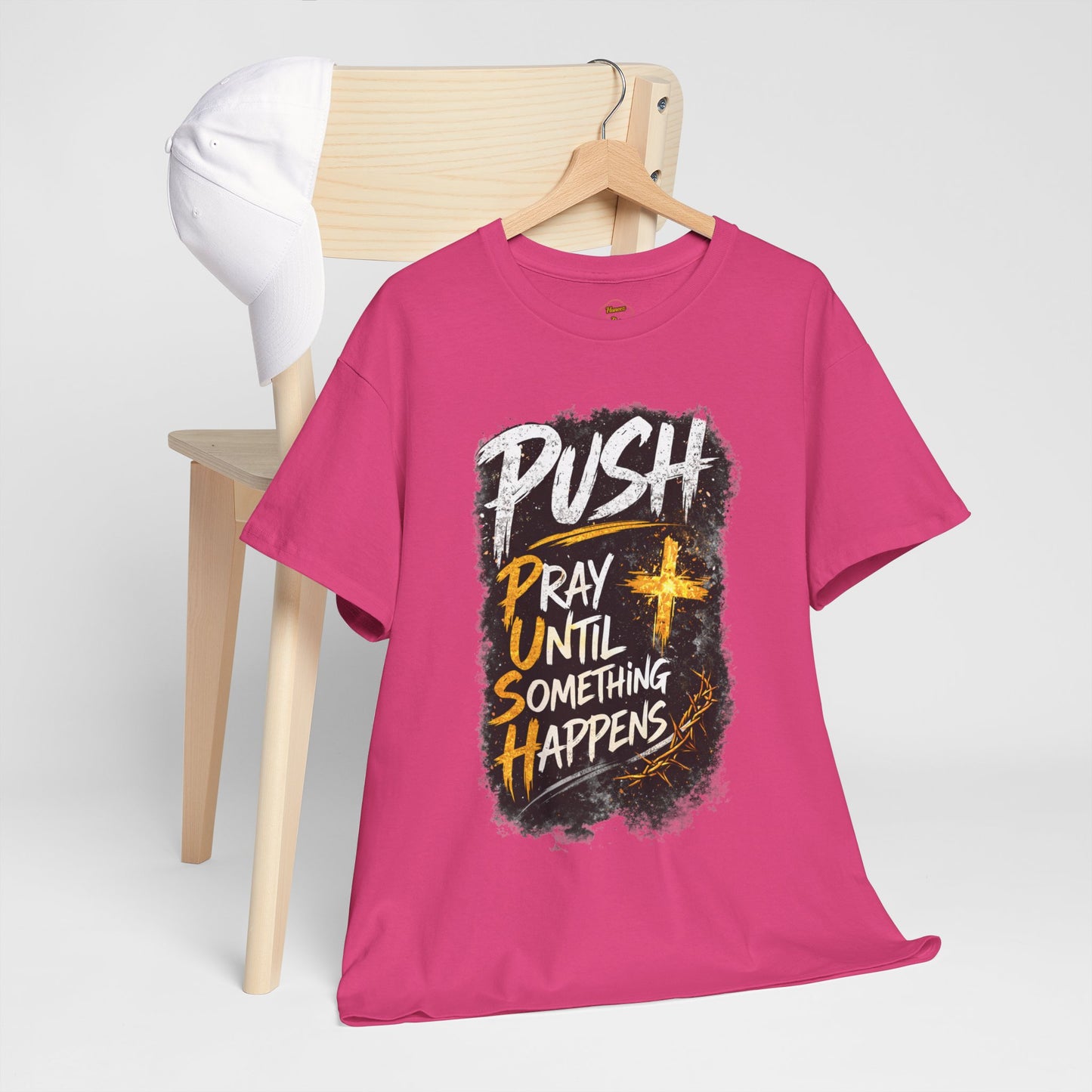 Pink t-shirt with motivational text on a wooden chair against a white background